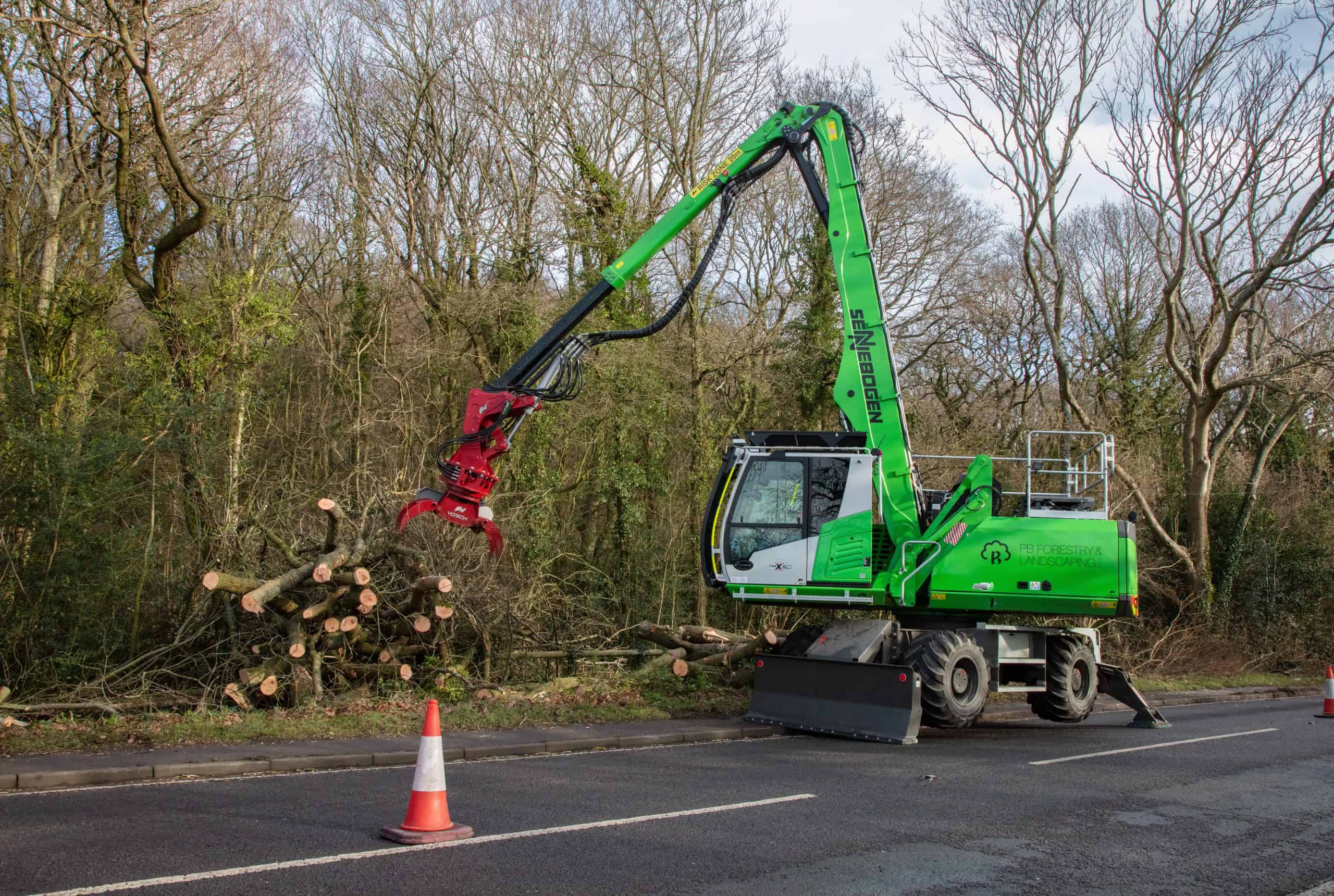 Sennebogen 718 stacking felled ash stems on the verge beside a coned-off carriageway